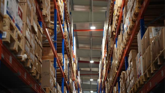 A logistics manager using a tablet to check inventory levels in a warehouse