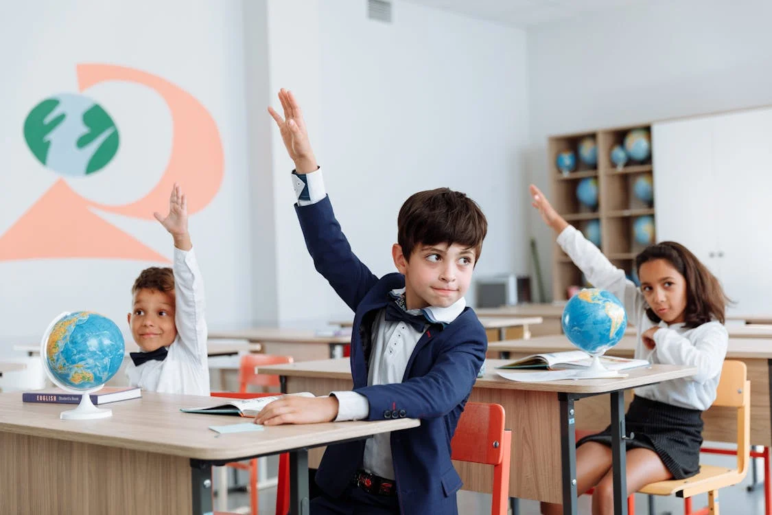 students raising their hands for attendance registration